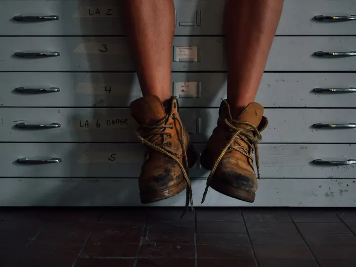 A pair of scuffed tan lace-up work boots