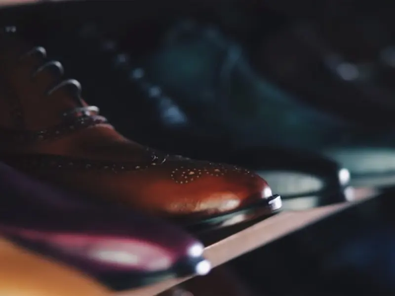 A row of polished brown and black brogues on a shelf