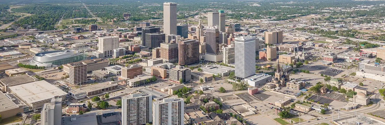 Downtown Tulsa from the air: a cluster of office towers among low buildings and trees